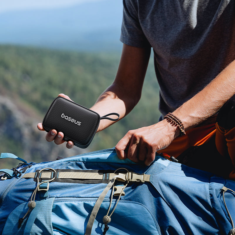 Person holding a black 'boseus' device with a scenic background