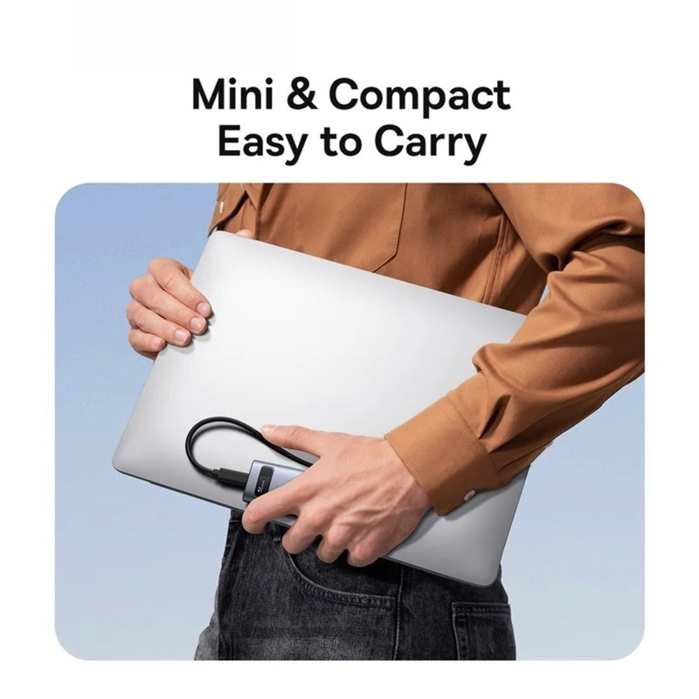 A person in a brown shirt carries a compact silver laptop under their arm, with a black cable plugged into the laptop. The text at the top reads 'Mini & Compact Easy to Carry' on a white background with a rounded gray frame around the inset photo.