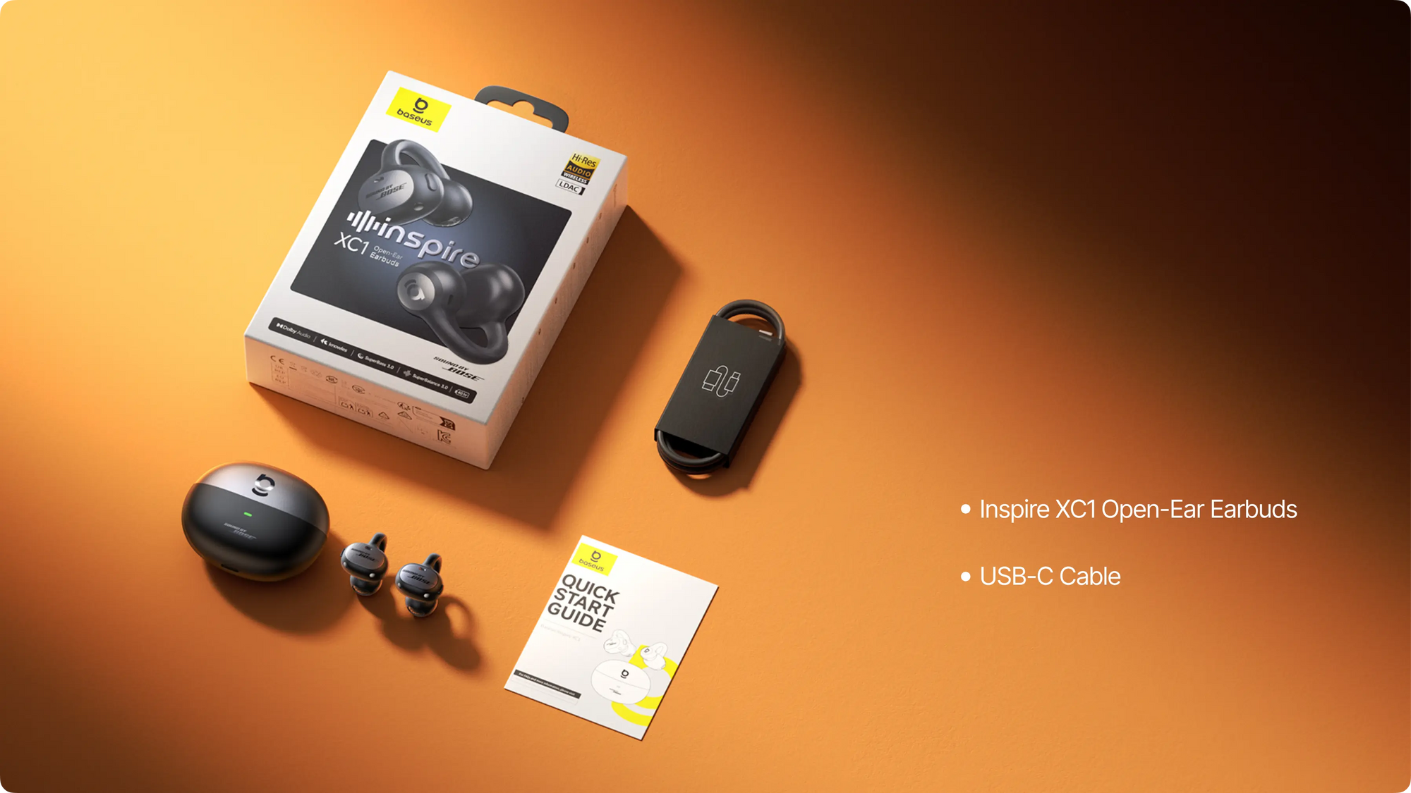 JLab Inspire XC1 open-ear earbuds packaging with earbuds and USB-C cable on an orange background