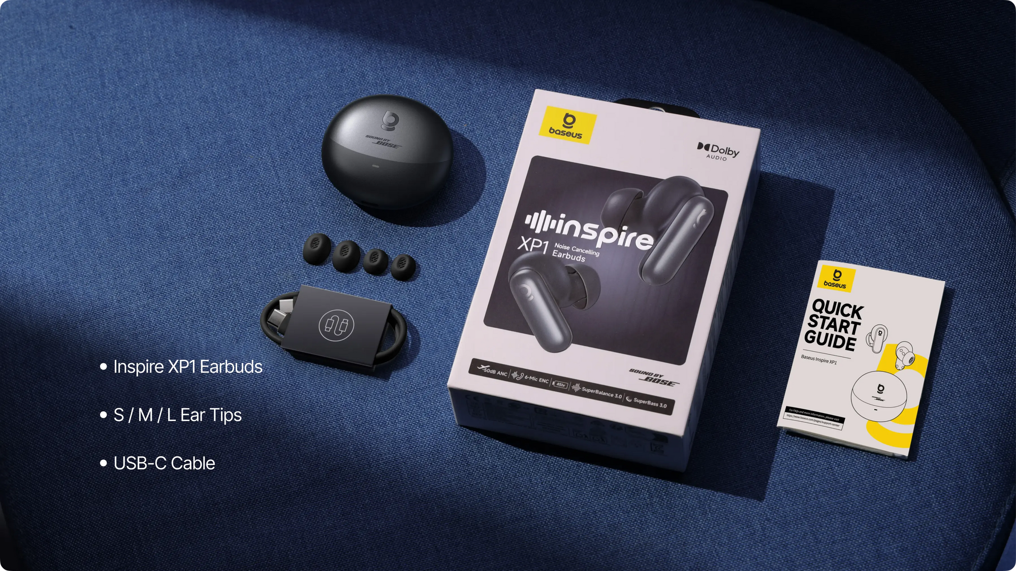 Inspire XPL earbuds with packaging and accessories on a blue surface